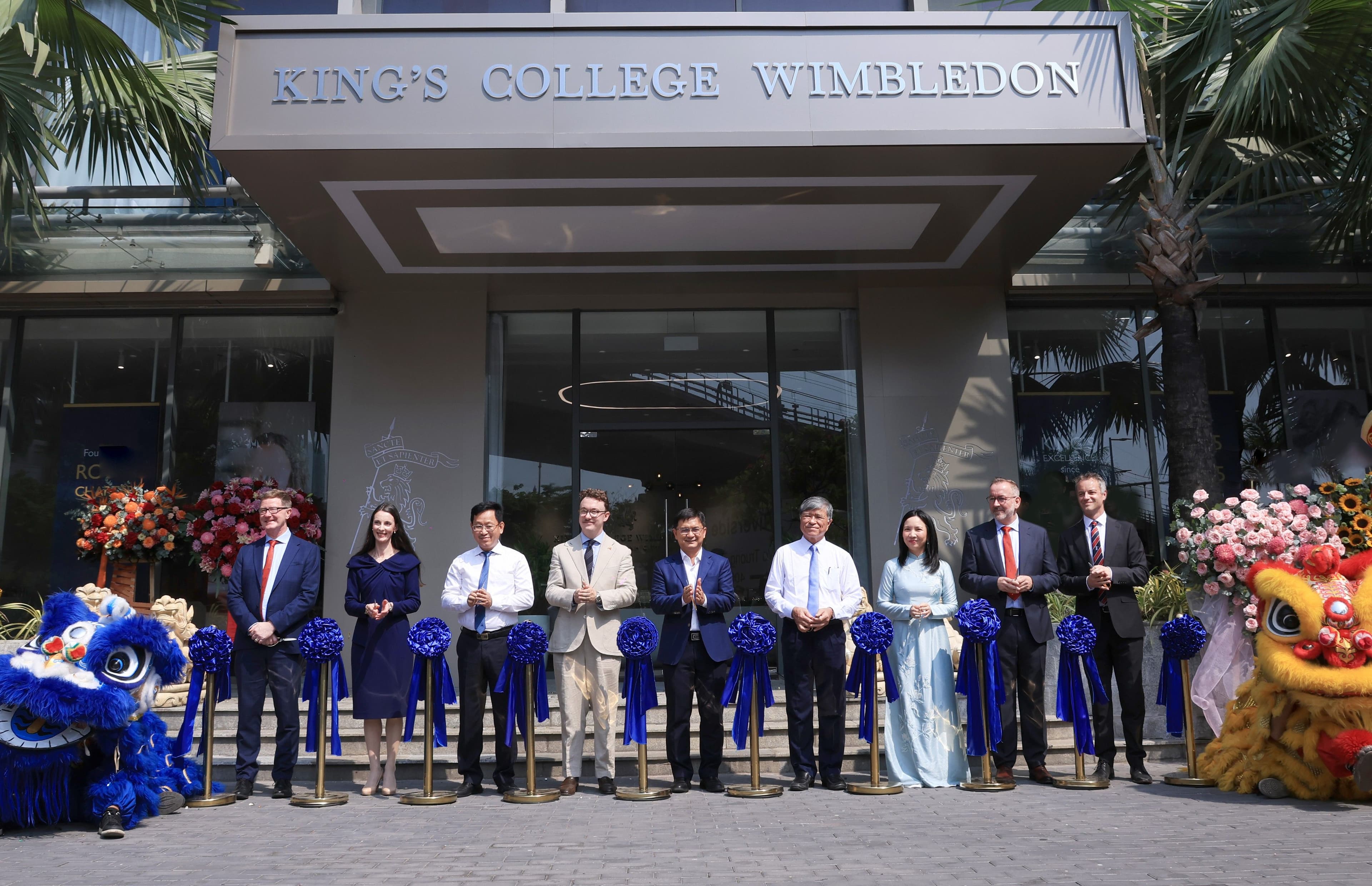 Officials cutting a ribbon in front of King's College Wimbledon building during an opening ceremony.